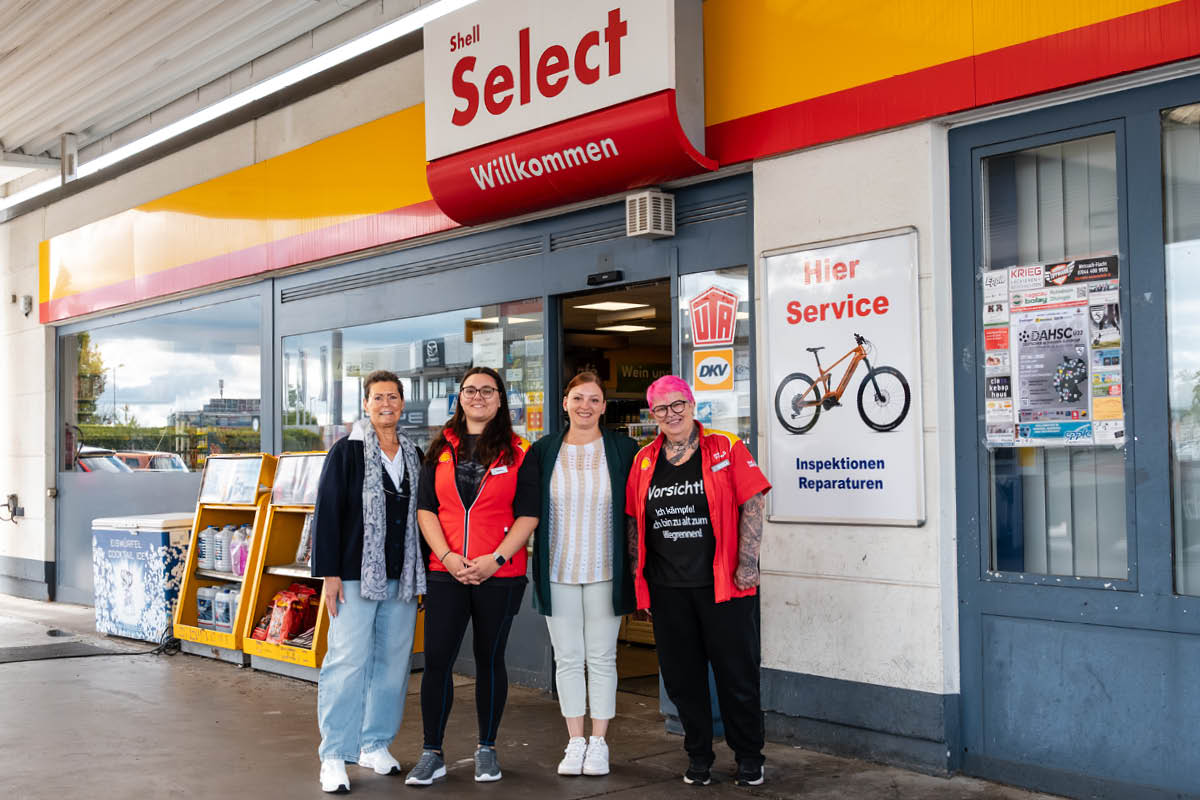 Unsere Mitarbeiter stehen vorm Eingang der Tankstelle